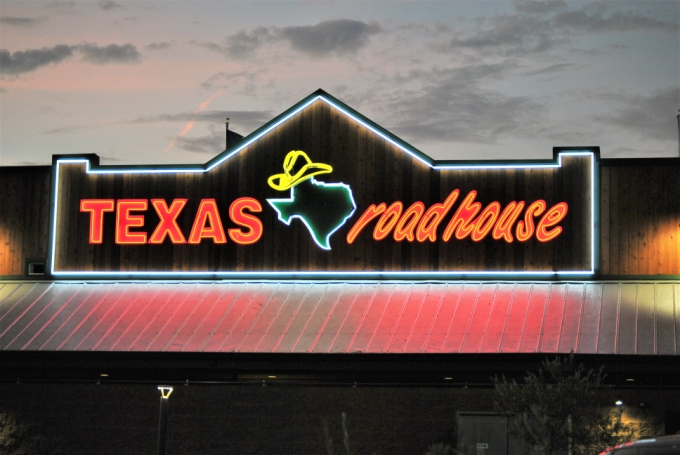 Texas Roadhouse neon sign glowing at dusk